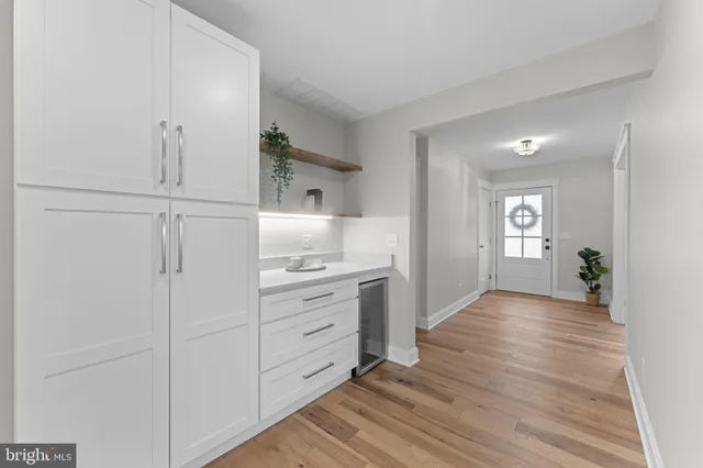 a large white kitchen with kitchen island a sink stainless steel appliances and cabinets