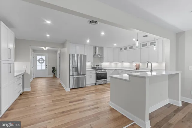 a kitchen with stainless steel appliances granite countertop a refrigerator sink and wooden cabinets