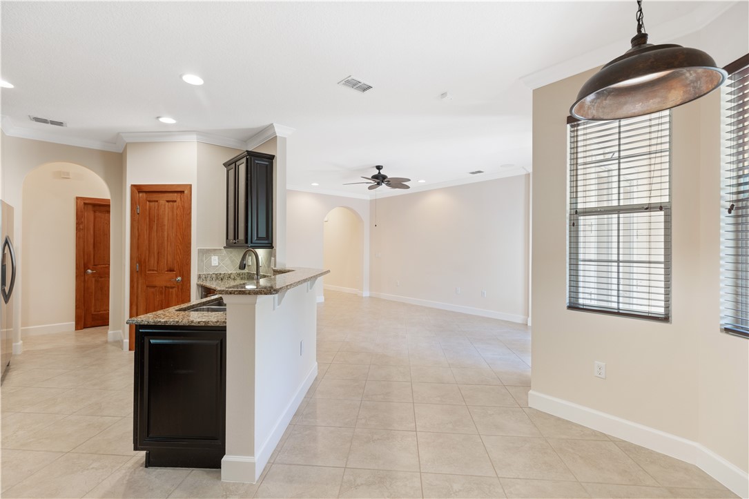 4231 Diamond Square Vero Beach, FL 32967 - Photo 11 of 28 a kitchen with kitchen island granite countertop a sink cabinets and stainless steel appliances