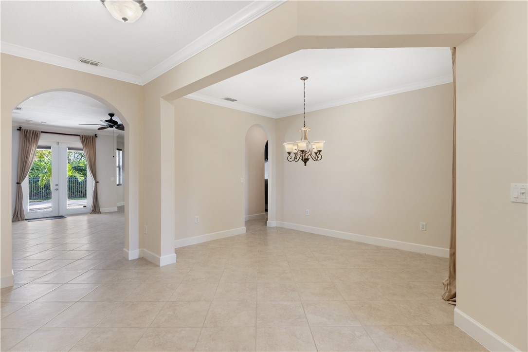 4231 Diamond Square Vero Beach, FL 32967 - Photo 16 of 28 an empty room with chandelier fan and windows
