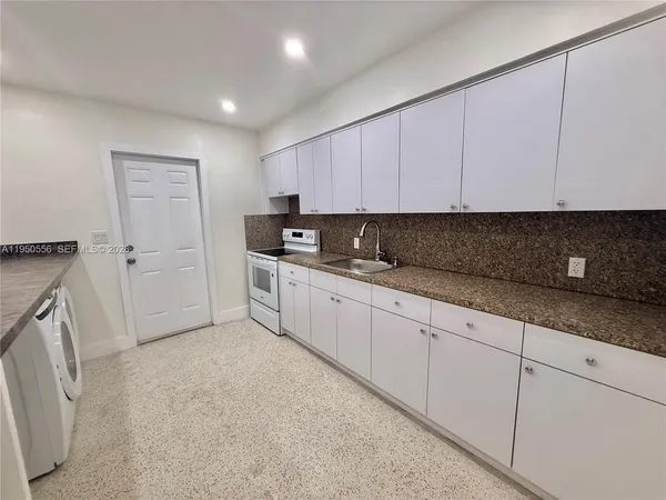 a kitchen with white cabinets and white appliances