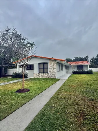 a house with a big yard and large trees