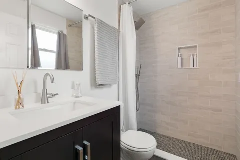 a bathroom with a sink a toilet and shower