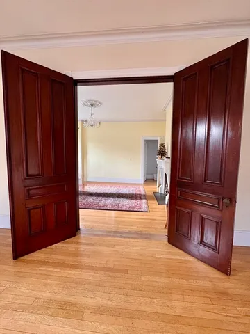 a view of empty room with wooden floor