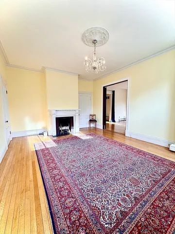 a bed sitting in a spacious bedroom and a chandelier