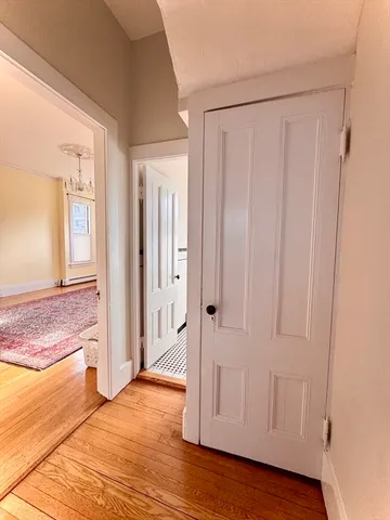 a view of an empty room with window and wooden floor