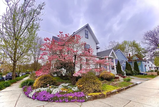 a front view of a multi story residential apartment building with yard and retail shops