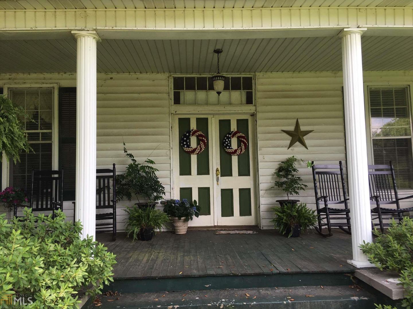 233 Euel Saggus Road Tignall, GA 30668 - Photo 1 of 1 a view of a brick house with potted plants and a large window