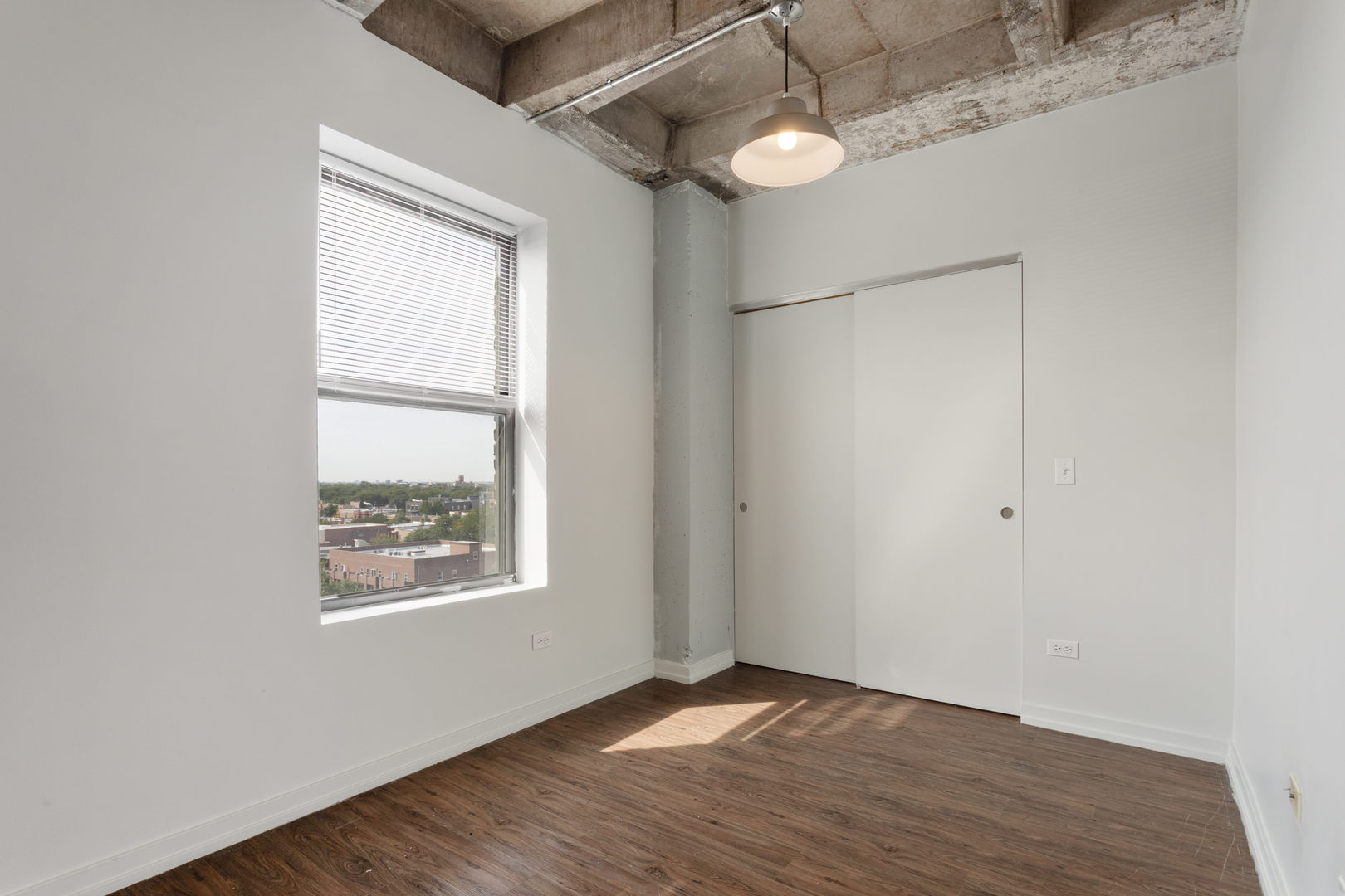 1325 West Wilson Avenue, Unit 605 Chicago, IL 60640 - Photo 7 of 20 a view of an empty room with wooden floor and a window