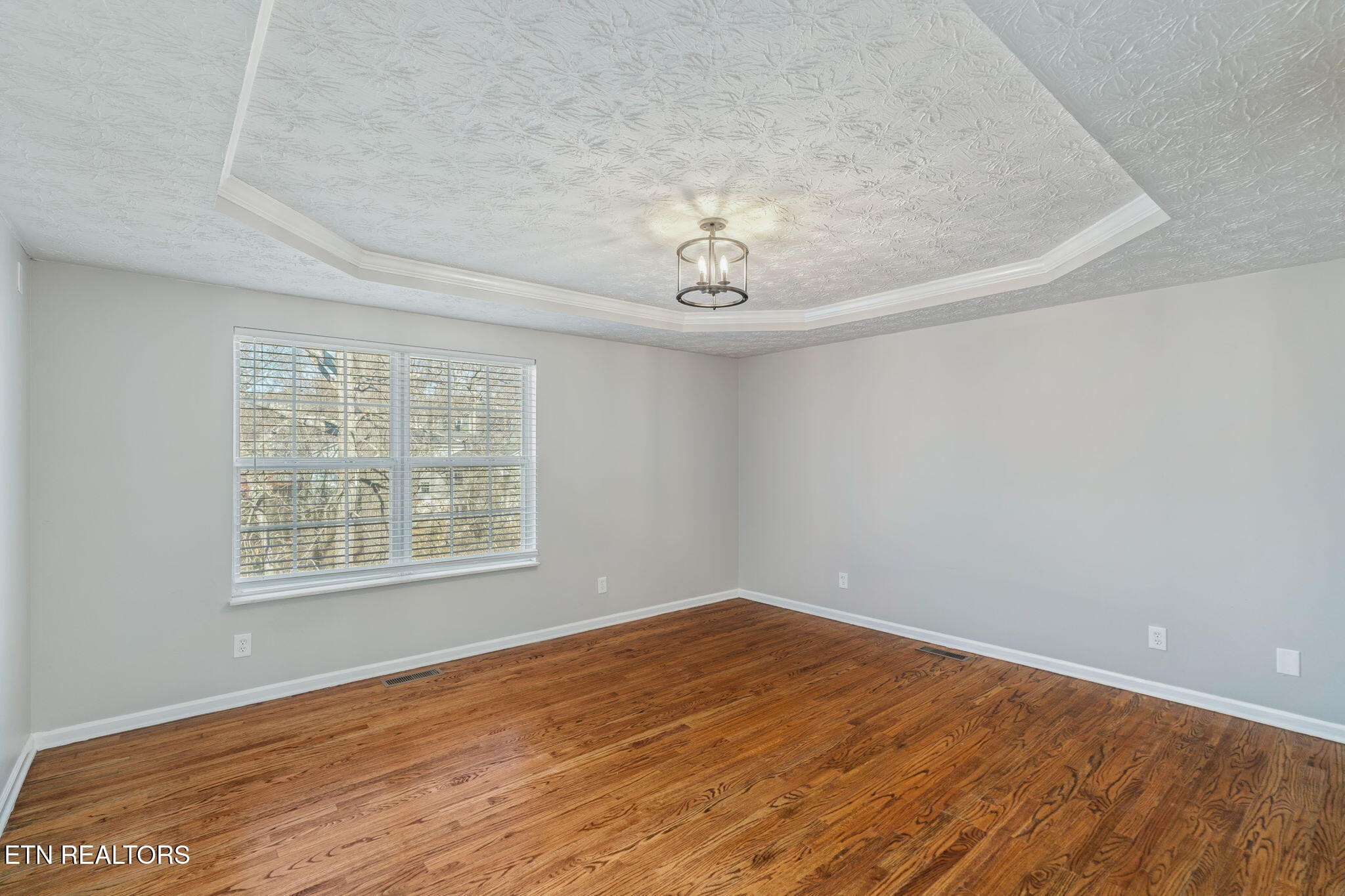 8533 Constance Way Knoxville, TN 37923 - Photo 13 of 30 a view of an empty room with wooden floor and a window