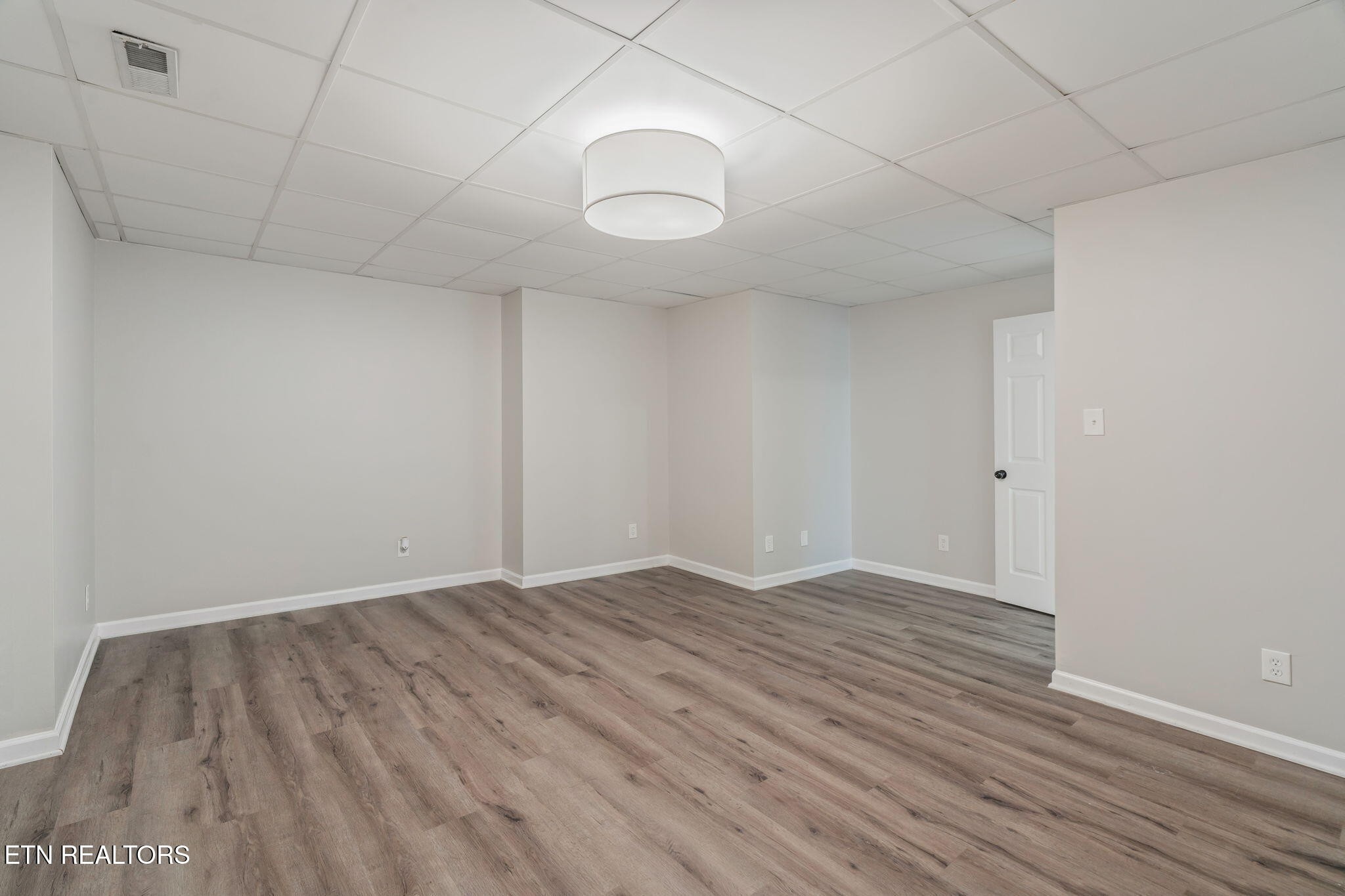 8533 Constance Way Knoxville, TN 37923 - Photo 20 of 30 a view of an empty room with wooden floor and a window