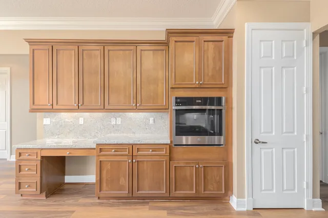 a kitchen with granite countertop white cabinets and stainless steel appliances