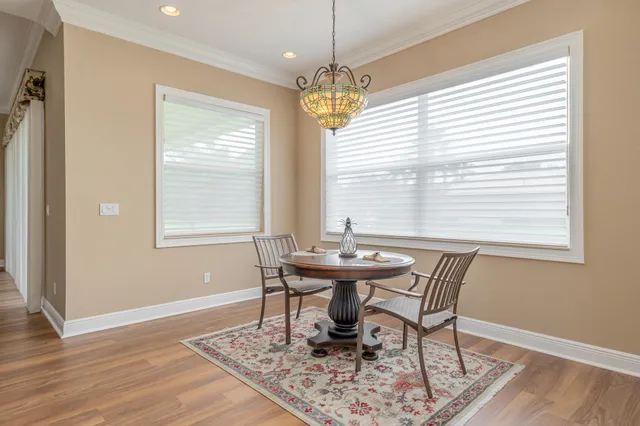 a dining room with furniture a chandelier and wooden floor
