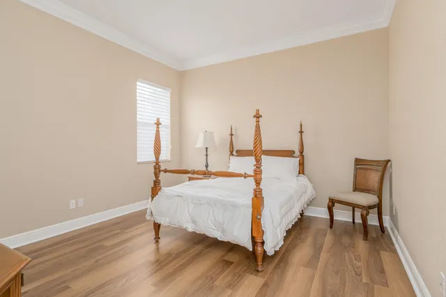 a large bed sitting in a spacious bedroom next to a window and a chair