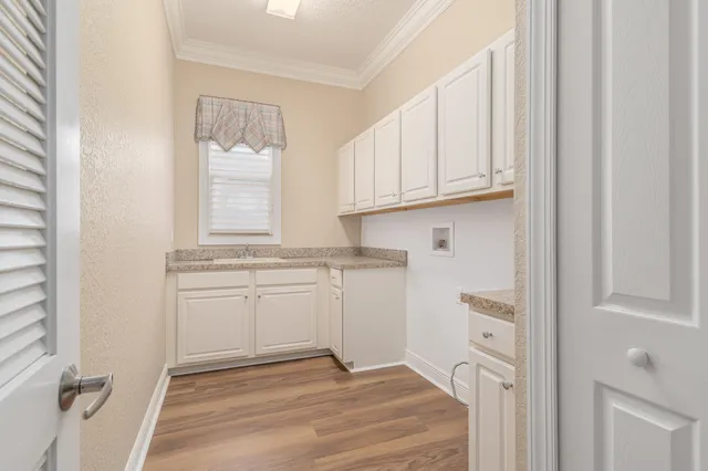 a view of a kitchen with white cabinets and a window