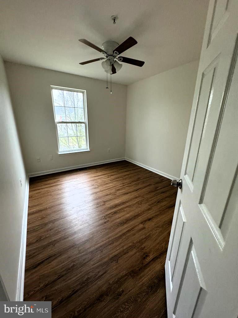 7520 Maury Road Baltimore, MD 21244 - Photo 13 of 29 an empty room with wooden floor fan and windows
