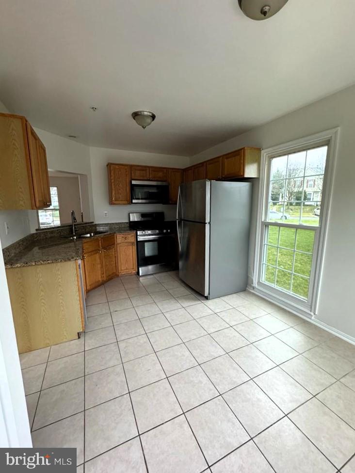 7520 Maury Road Baltimore, MD 21244 - Photo 3 of 29 a kitchen with stainless steel appliances a stove a sink a microwave a counter top and cabinets