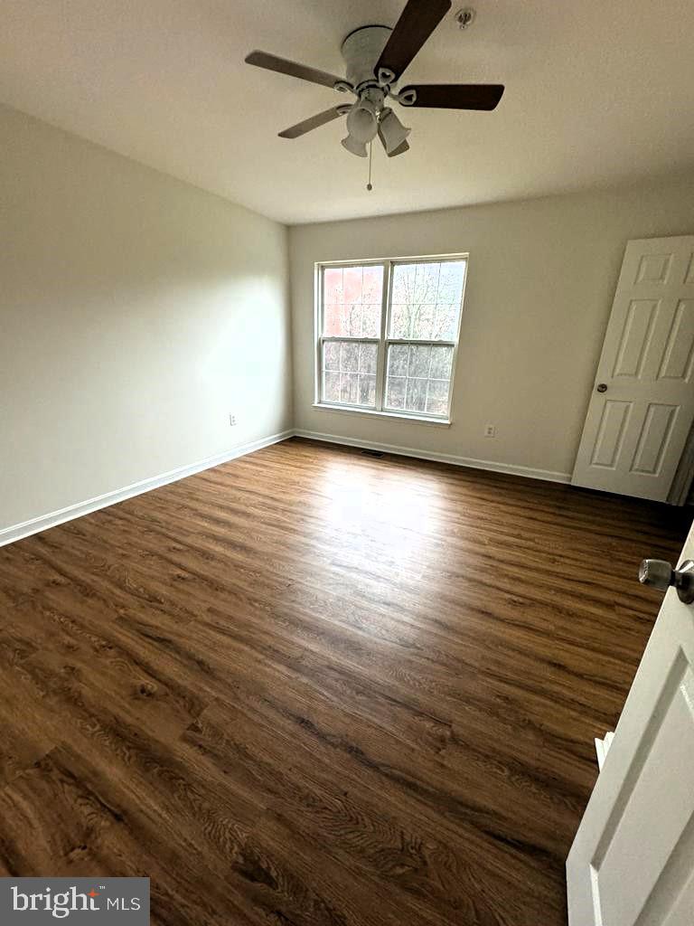 7520 Maury Road Baltimore, MD 21244 - Photo 10 of 29 an empty room with wooden floor fan and windows