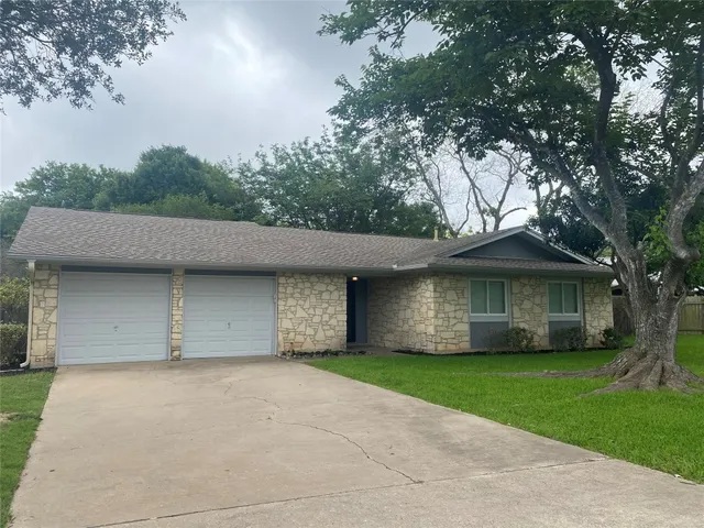 a front view of a house with a garden and trees