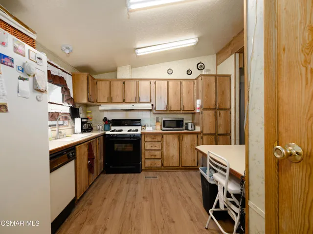 a kitchen with a refrigerator a sink and wooden cabinets