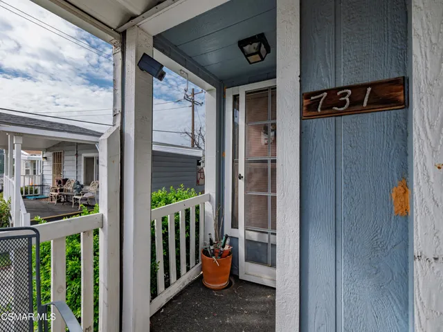 a view of a porch with furniture and floor to ceiling window
