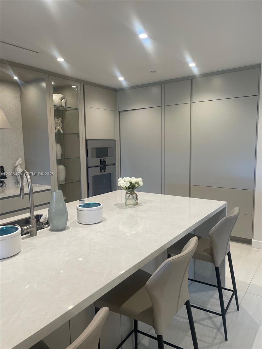 220 Southeast Mizner Boulevard, Unit 321 Boca Raton, FL 33432 - Photo 5 of 24 a kitchen with kitchen island a sink table and chairs