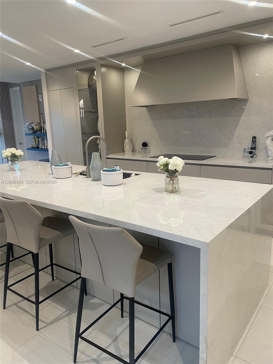 220 Southeast Mizner Boulevard, Unit 321 Boca Raton, FL 33432 - Photo 6 of 24 a kitchen with a sink and chairs