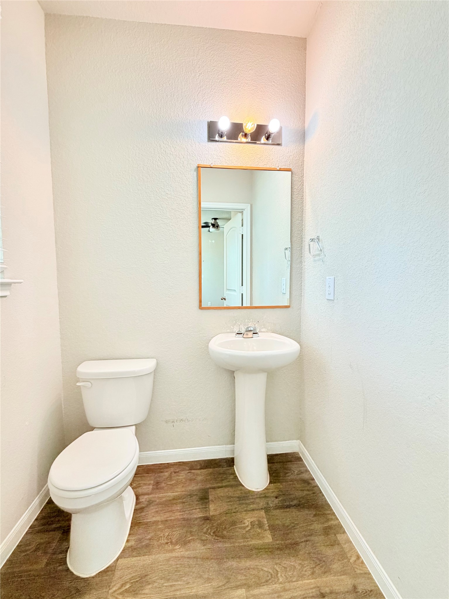 10502 Fulton Avenue Austin, TX 78754 - Photo 14 of 36 A well-maintained bathroom with a pedestal sink and modern vanity lighting.