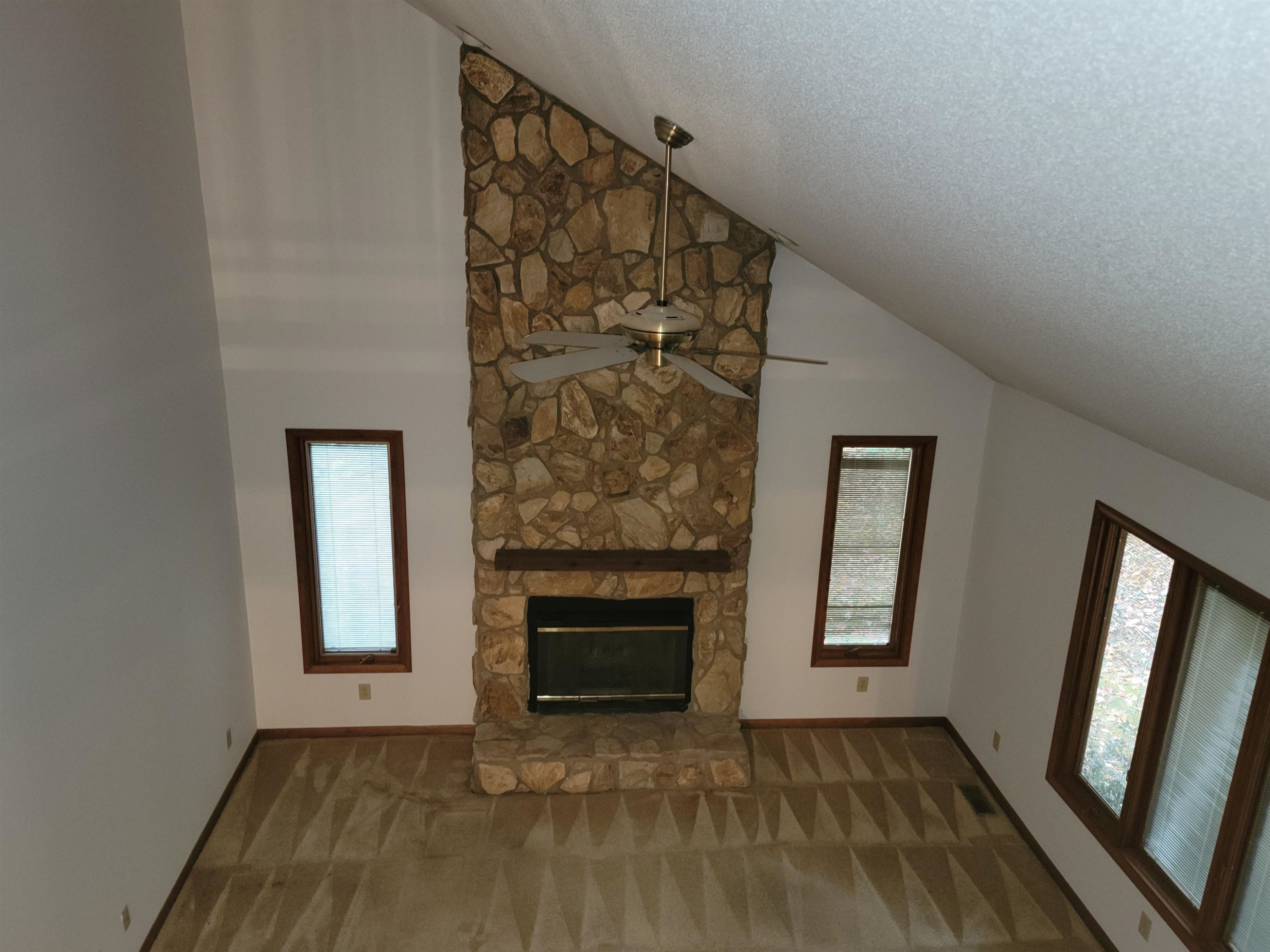 7816 Netherlands Drive Raleigh, NC 27606 - Photo 11 of 60 an empty room with wooden floor fireplace and windows