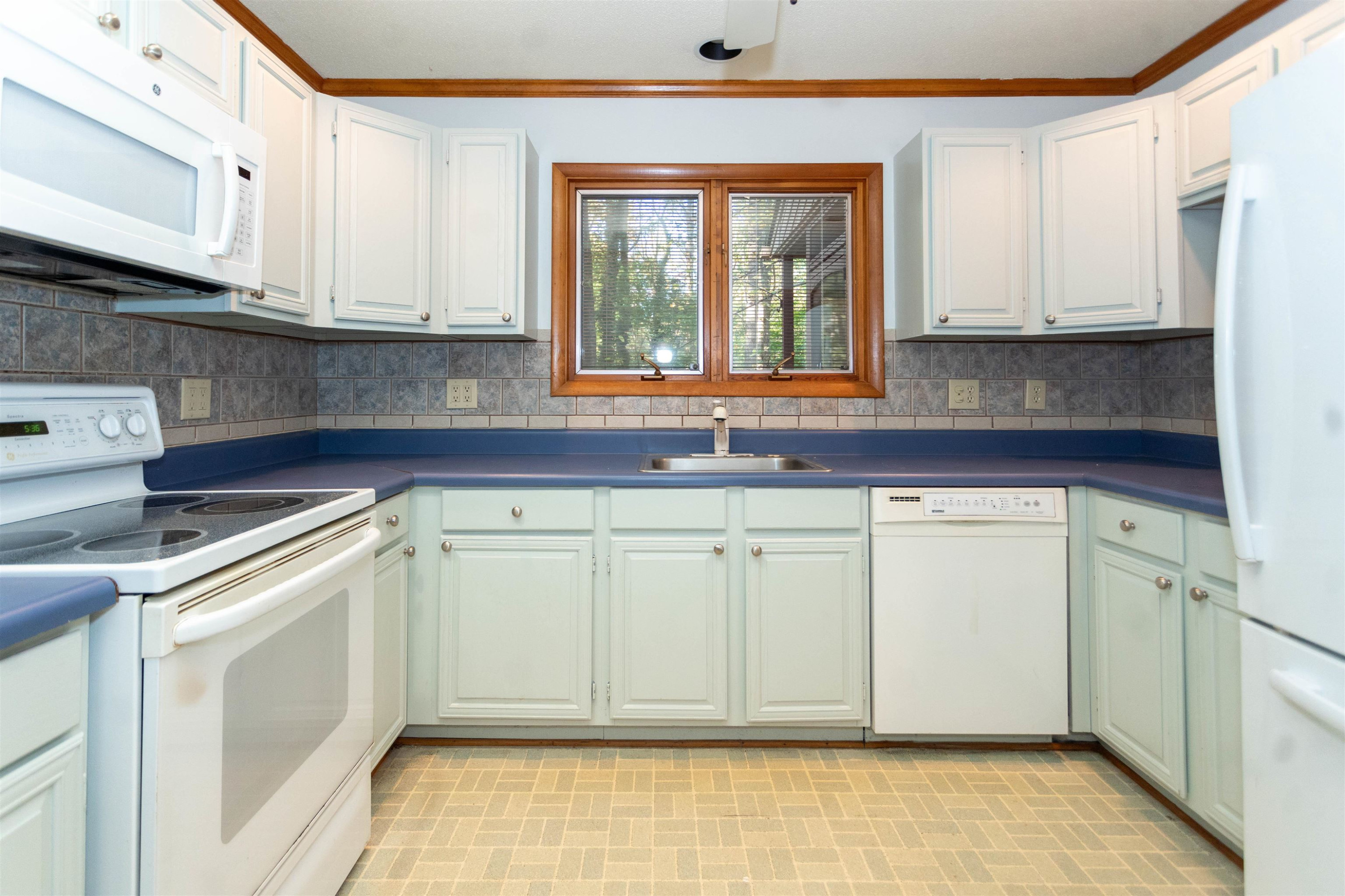 7816 Netherlands Drive Raleigh, NC 27606 - Photo 15 of 60 a kitchen with white cabinets and white appliances