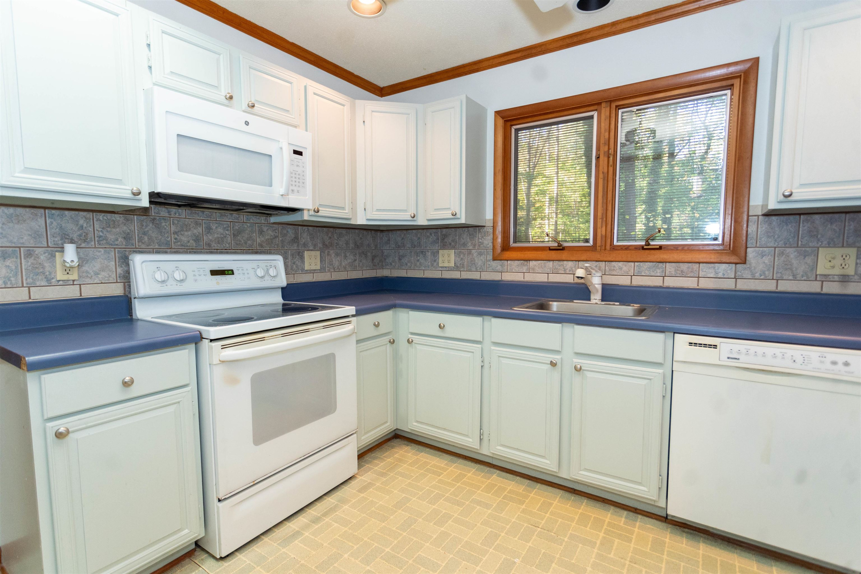 7816 Netherlands Drive Raleigh, NC 27606 - Photo 28 of 60 a kitchen with white cabinets and white appliances