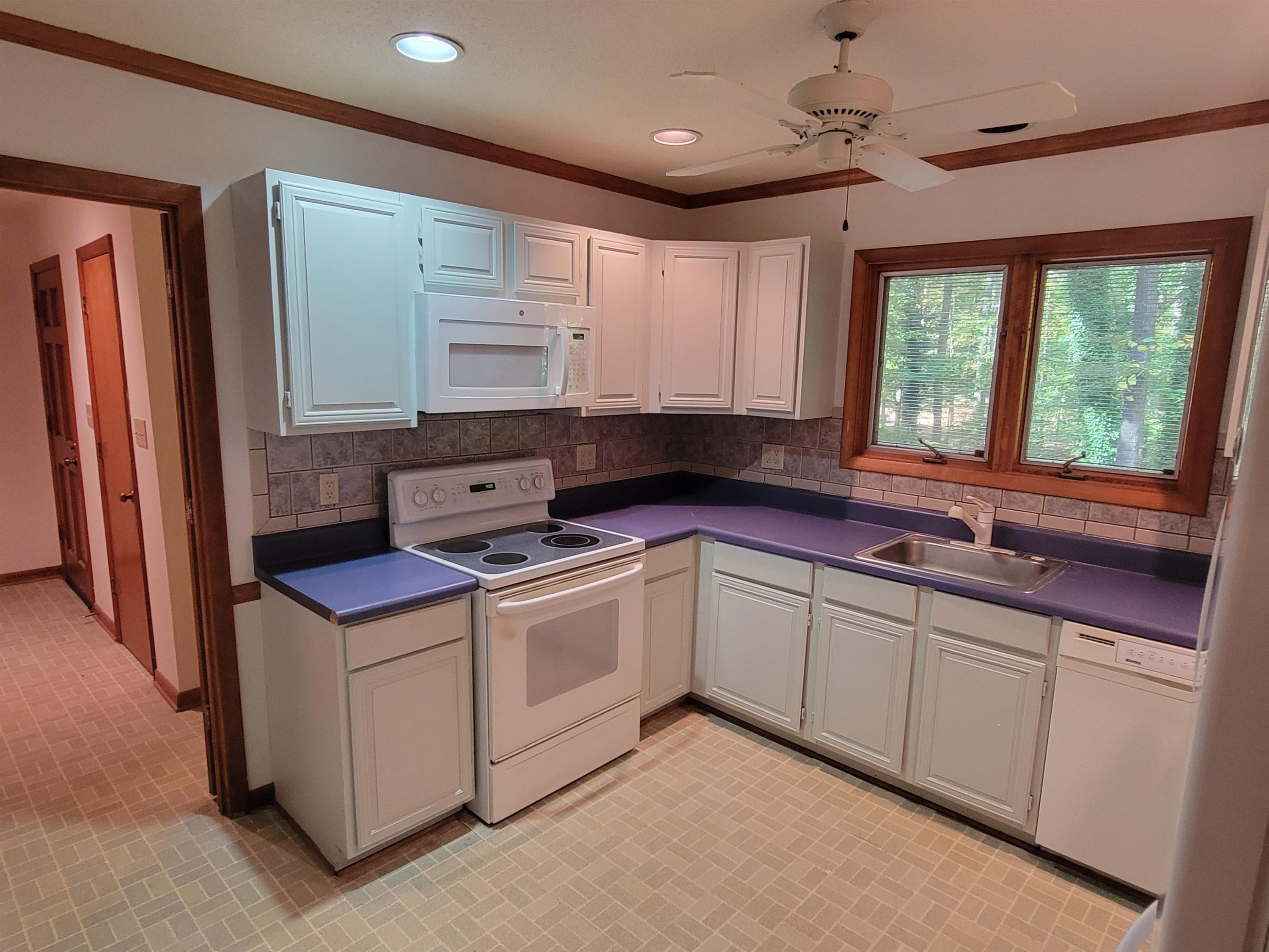 7816 Netherlands Drive Raleigh, NC 27606 - Photo 30 of 60 a kitchen that has a sink and a stove in it