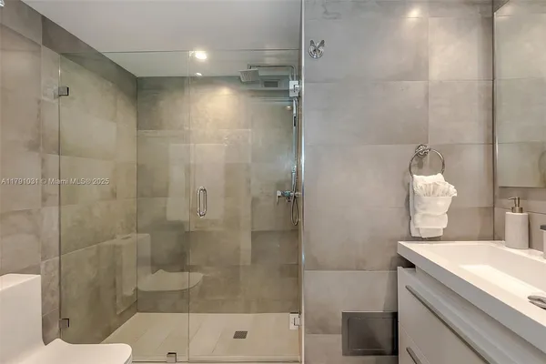 a bathroom with a shower sink and mirror