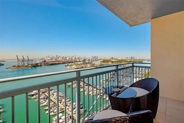 a balcony with wooden floor table and chairs