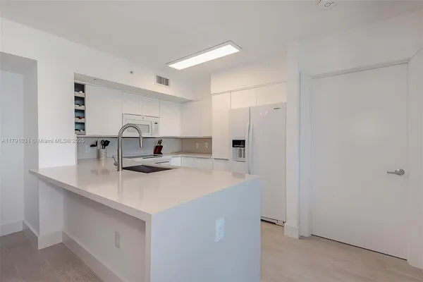 a kitchen with a sink and a refrigerator