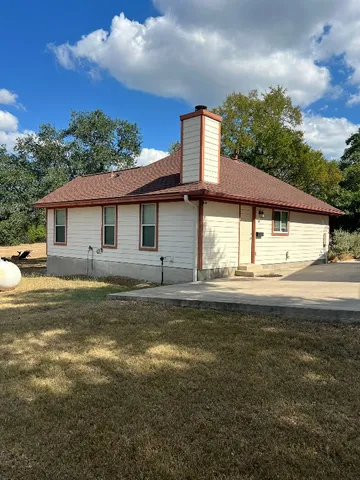 a view of a house with pool and a yard