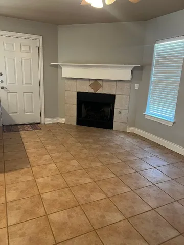 a view of an empty room with a fireplace and a window
