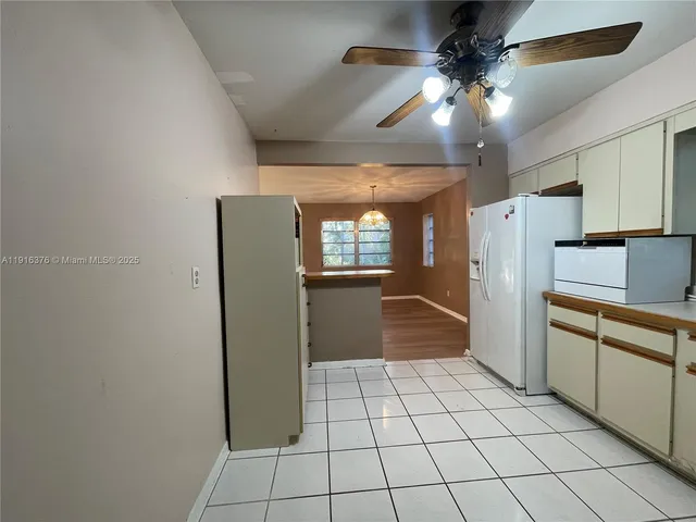 a kitchen with a refrigerator a microwave and cabinets