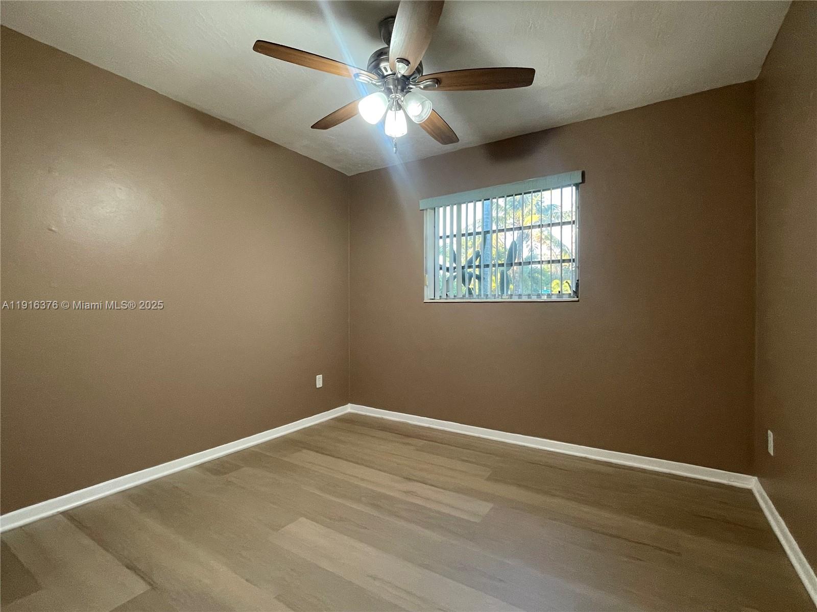 19700 Whispering Pines Road Cutler Bay, FL 33157 - Photo 12 of 27 en empty room with windows and ceiling fan