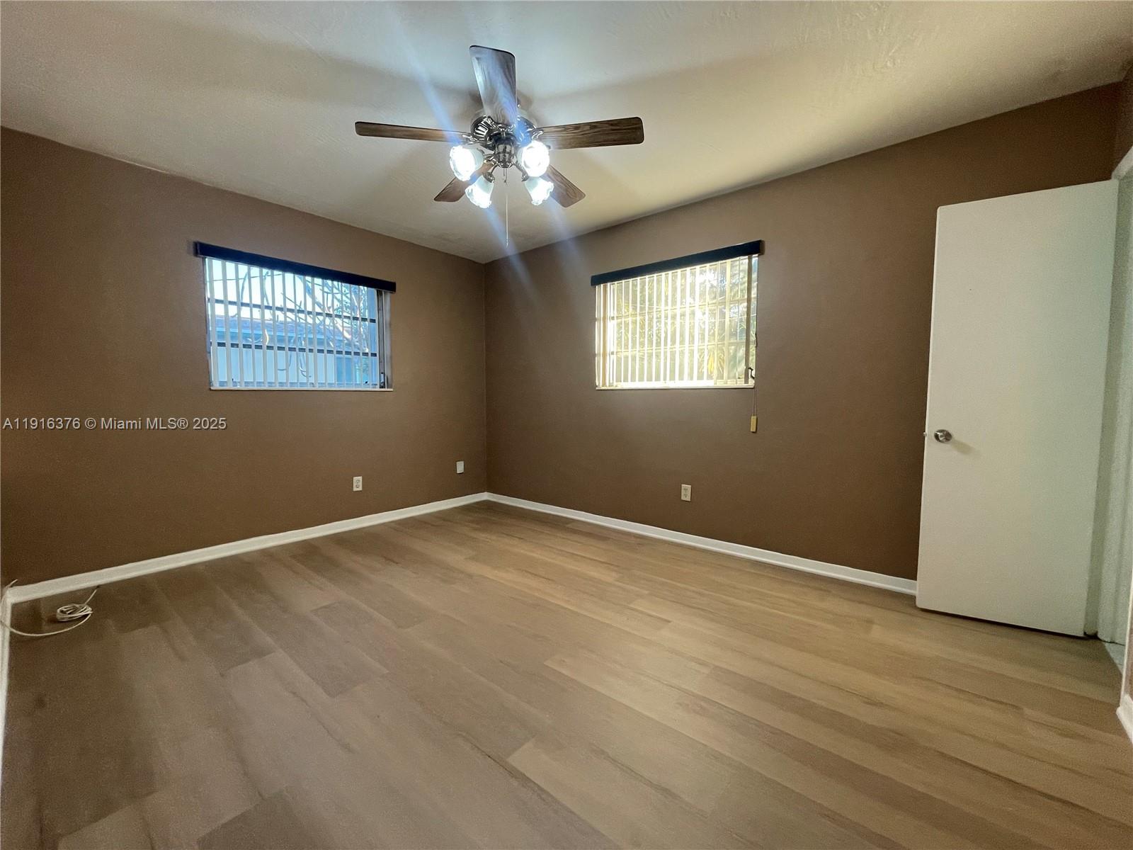 19700 Whispering Pines Road Cutler Bay, FL 33157 - Photo 15 of 27 an empty room with wooden floor closet and windows