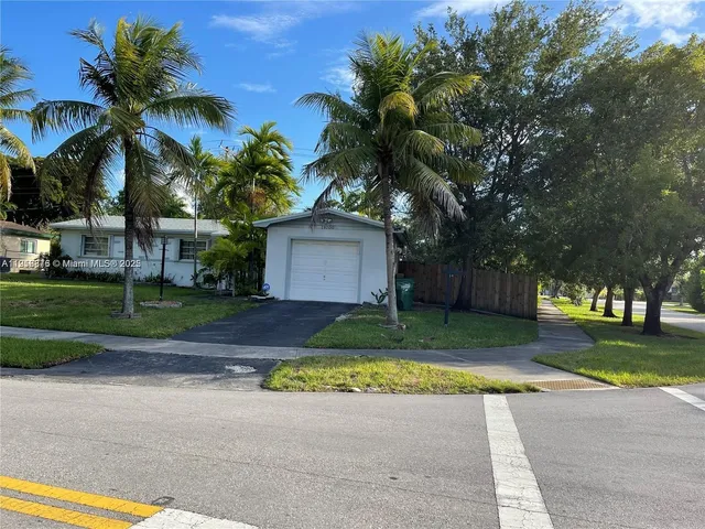 a view of a house with a yard and palm trees