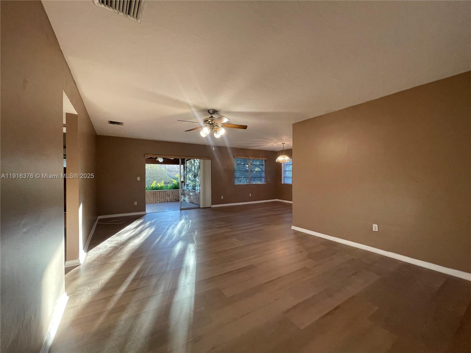19700 Whispering Pines Road Cutler Bay, FL 33157 - Photo 5 of 27 a view of a hallway with wooden floor and a chandelier
