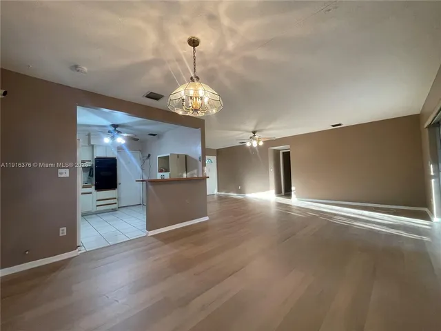 a view of a kitchen with a sink and dishwasher wooden floor and a large window