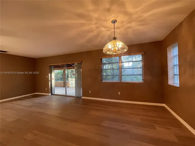 a view of wooden floor and windows in a room