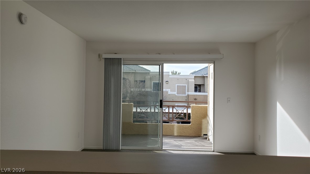 8070 West Russell Road, Unit 2105 Las Vegas, NV 89113 - Photo 3 of 10 A spacious, airy room opens onto a private balcony, offering neighborhood views.