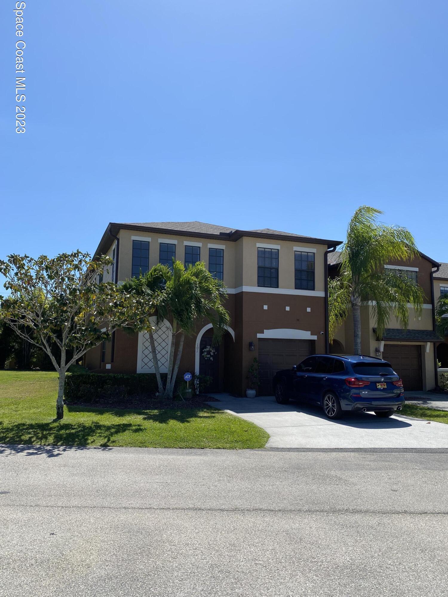 a front view of a house with a yard and a garage