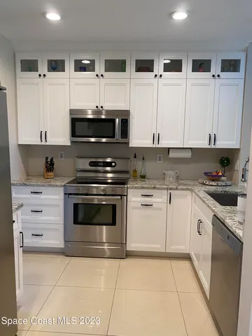 a kitchen with stainless steel appliances granite countertop a stove and white cabinets