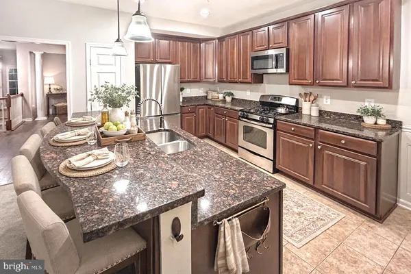 a kitchen with stainless steel appliances granite countertop a stove top oven a sink dishwasher and cabinets with wooden floor