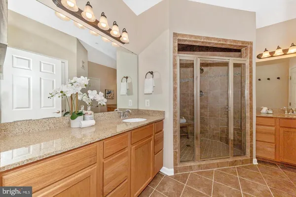 a bathroom with a shower a mirror and a sink
