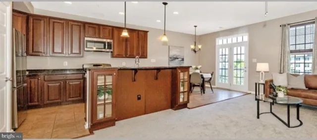 a living room with stainless steel appliances granite countertop furniture a fireplace and a window
